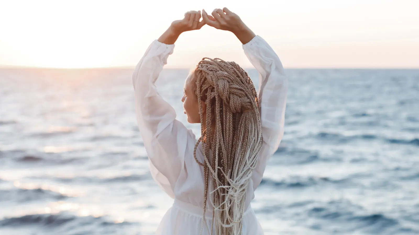 Girl standing by the ocean with arms raised, Start Quiz banner for personality and self-discovery test