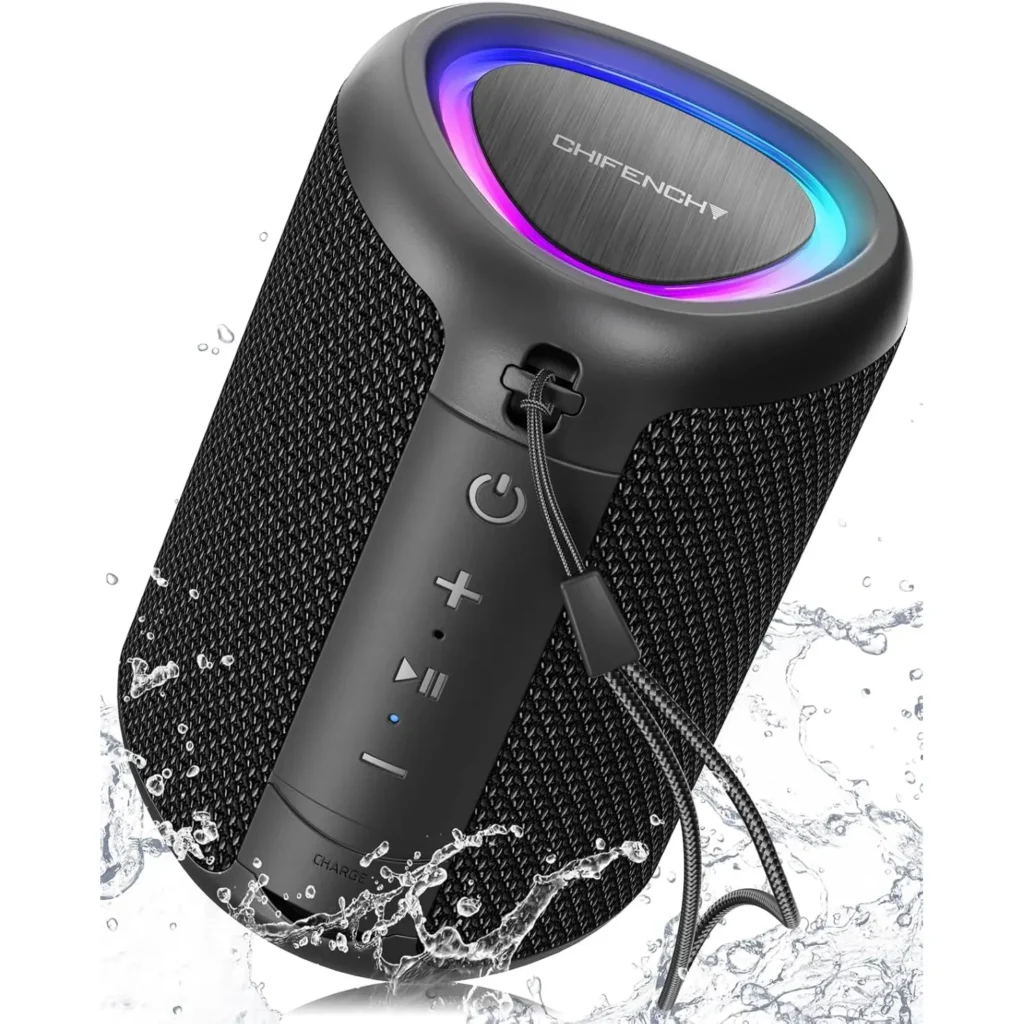 Black portable Bluetooth speaker with LED lighting on a white background, surrounded by water droplets, showcasing its waterproof design and wireless audio for outdoor or indoor use.
