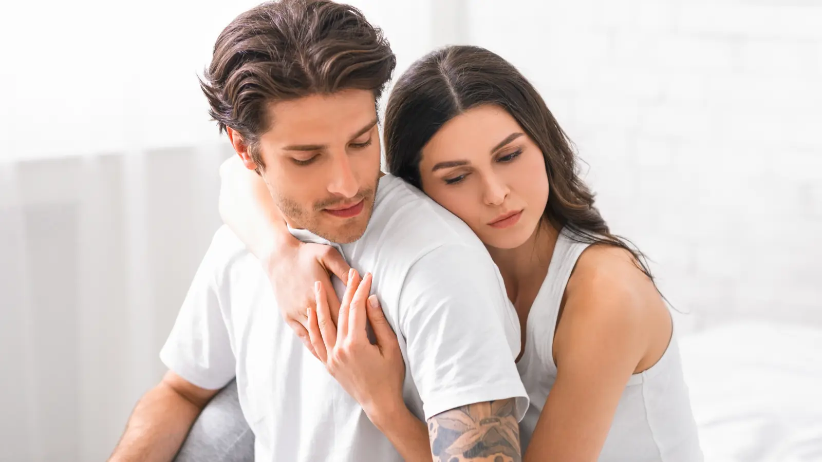 A sad young couple embracing each other, sharing a moment of comfort and emotional support during a difficult time.