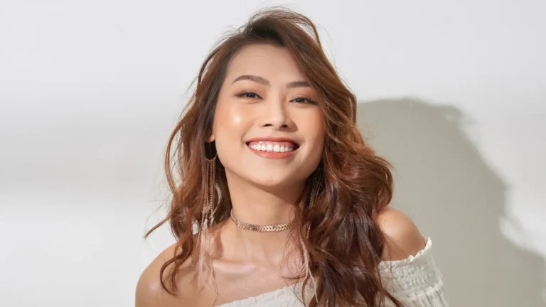 A happy young woman smiling with natural joy, showing confidence and positive energy in a bright, uplifting atmosphere