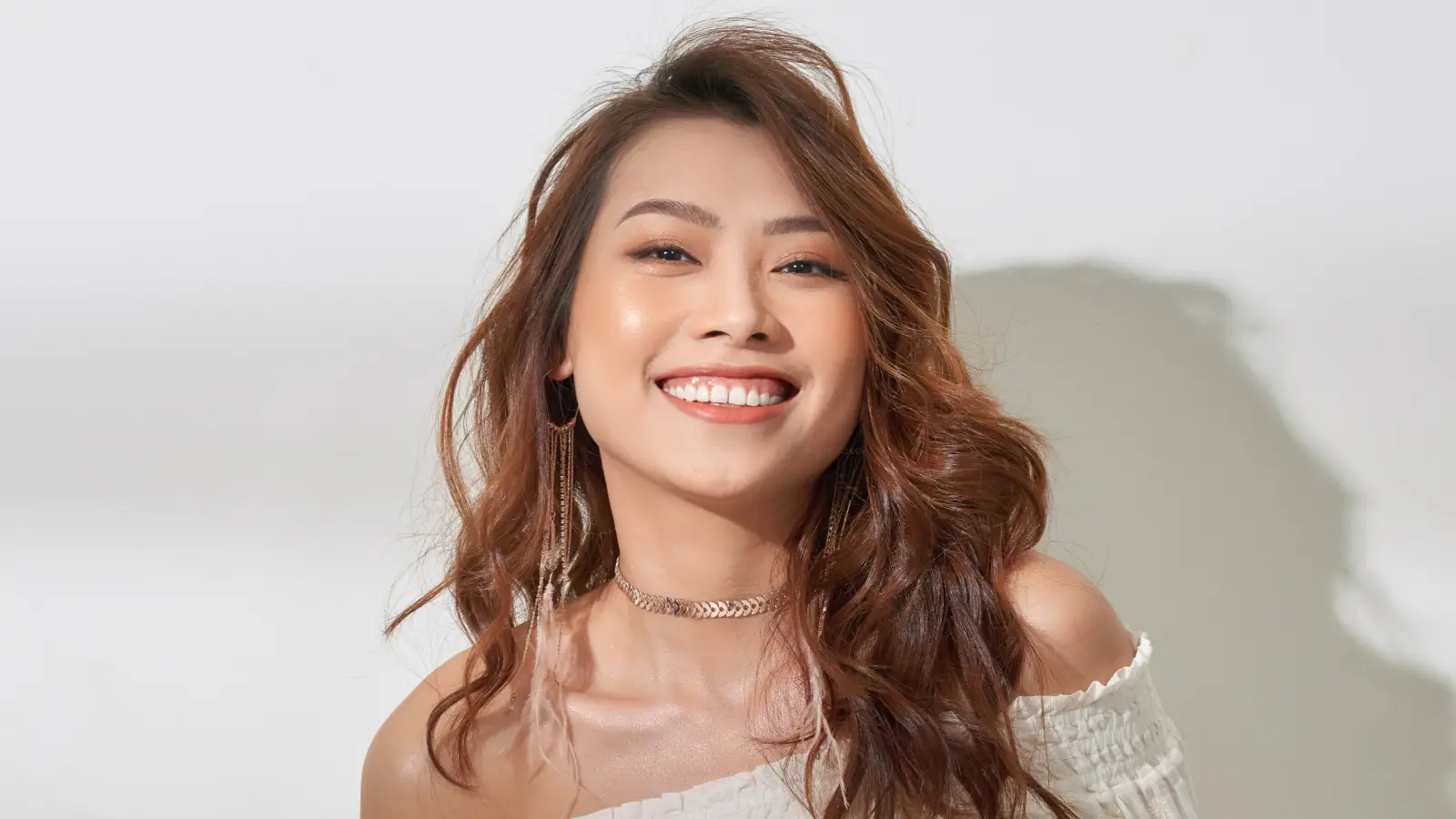 A happy young woman smiling with natural joy, showing confidence and positive energy in a bright, uplifting atmosphere